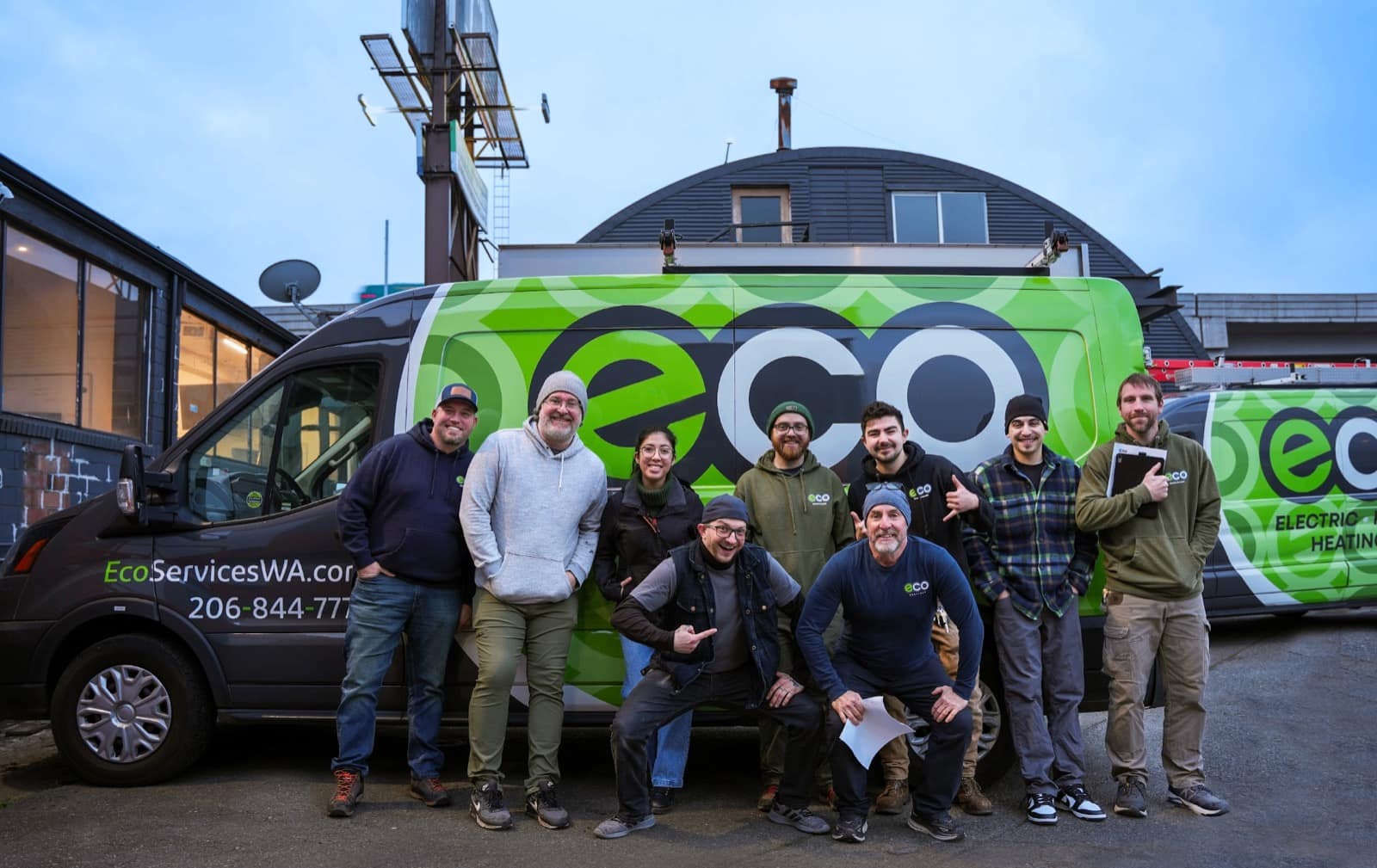 The Eco Electric, Plumbing, Heating & Air team in front of branded service vans