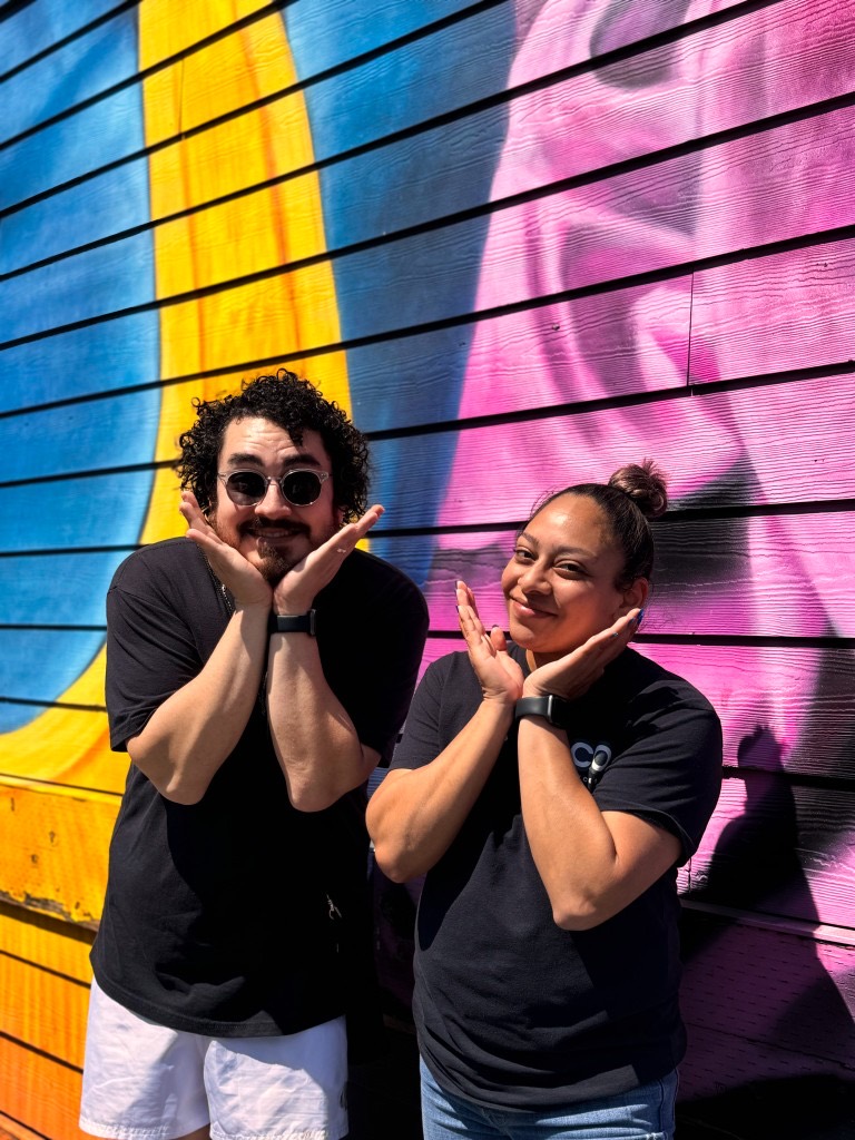 Eco team members having fun in front of a colorful Seattle mural
