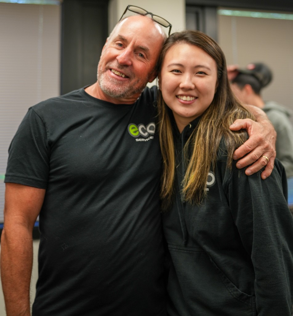 Two members of the Eco team smiling together at the office